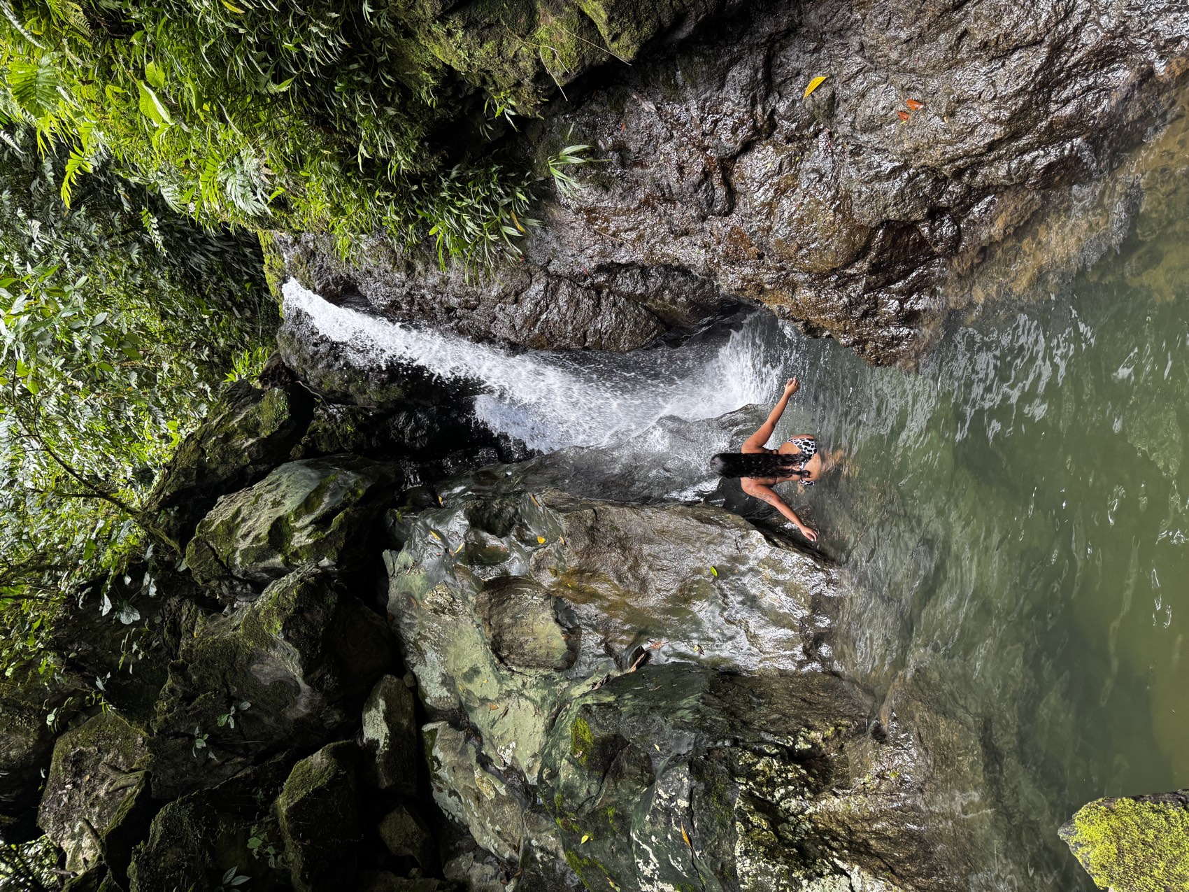 Persona bañándose en la poza natural de la Cascada de Terco