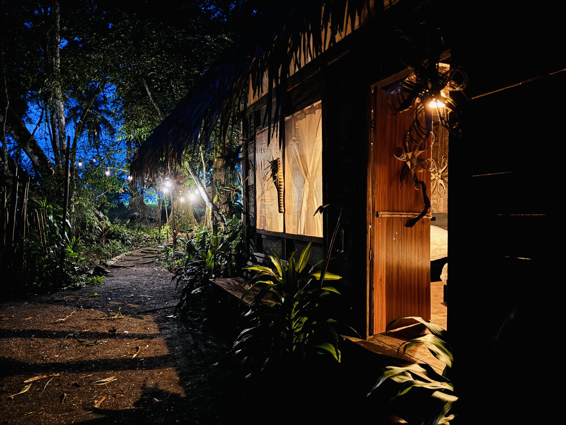 Cabaña de Nawala Eco-Hostel iluminada de noche entre la selva