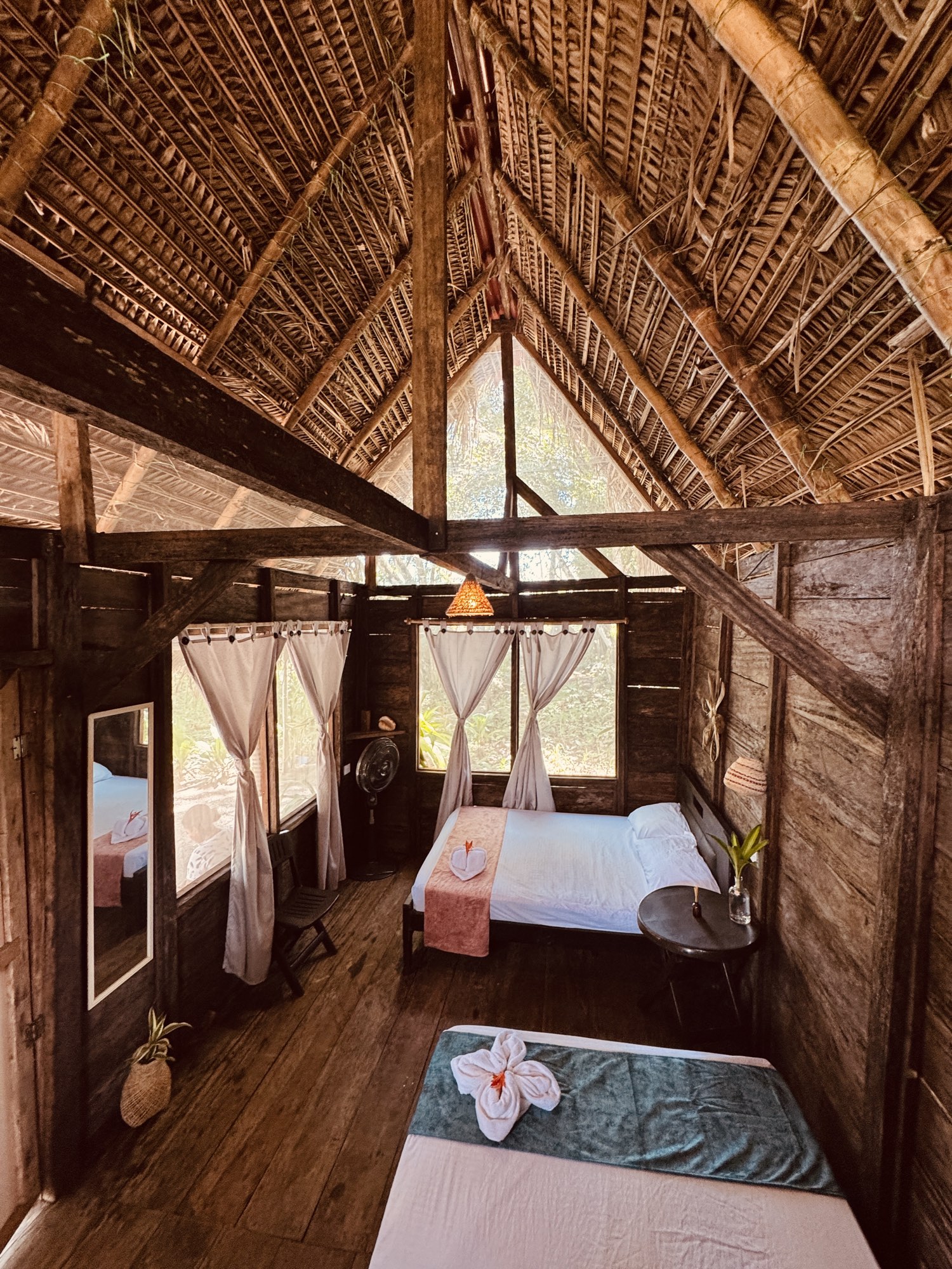 Interior de una cabaña de Nawala Eco-Hostel con techo de palma